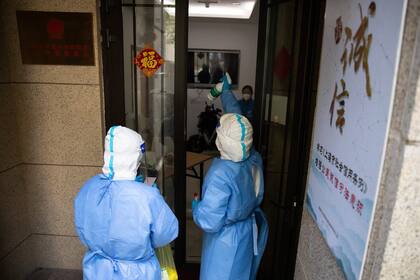 Personal médico desinfecta una vivienda en Shanghái