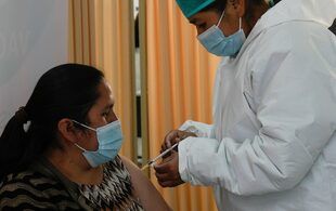 Personal médico vacuna a una mujer con el fármaco contra el COVID-19 Sputnik V en la Universidad Unifranz, durante una campaña para mayores de 30 años, en La Paz, Bolivia