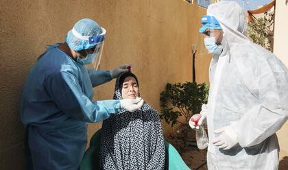 Personal sanitario palestino realiza un hisopado a un residente en el sur de la Franja de Gaza