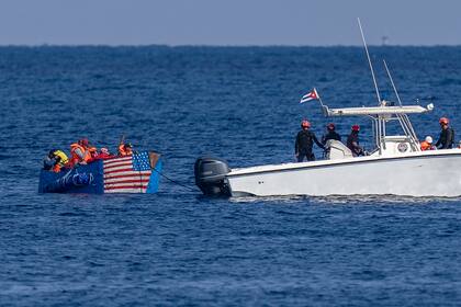 Personas a bordo de una balsa con una bandera estadounidense pintada a un costado son detenidas por la Guardia Costera de Cuba, el lunes 12 de diciembre de 2022, frente a La Habana. (AP Foto/Ramon Espinosa)