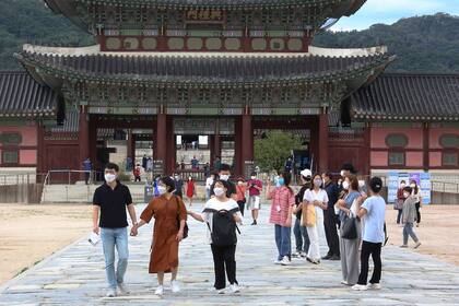 Personas con mascarillas para ayudar a protegerse contra la propagación del coronavirus visitan el Palacio Gyeongbok en Seúl, Corea del Sur, el domingo 13 de septiembre de 2020.