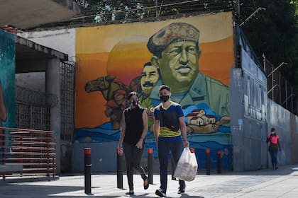 Las figuras de Chávez y, de fondo, Maduro, sueños revolucionarios ahora sustituidos por la realidad de unos ingresos insignificantes