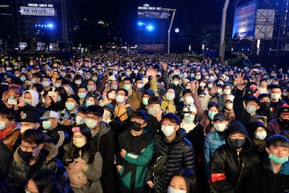 Personas con tapabocas participan en las celebraciones de Año Nuevo junto al edificio comercial Taipei 101 en Taipei, taiwán, el 1 de enero de 2021