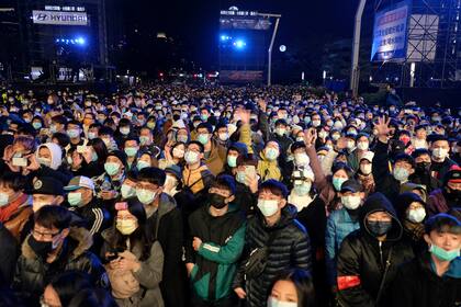 Personas con tapabocas participan en las celebraciones de Año Nuevo junto al edificio comercial Taipei 101 en Taipei, Taiwán, el 1 de enero de 2021