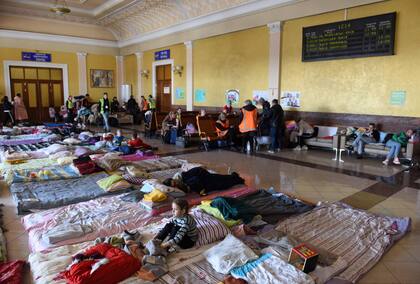 Personas descansan en una sala especial de una estación de tren de la ciudad ucraniana occidental de Lviv el 21 de marzo de 2022, en medio de la invasión rusa de Ucrania.