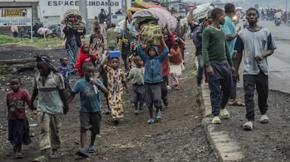 Personas desplazadas por los combates con los rebeldes caminan por la República Democrática del Congo