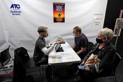 Personas entrevistadas antes de recibir la vacuna de Pfizer para el coronavirus en el ATC Vaccination Services en Times Square, Nueva York, el 12 de abril del 2021. (AP Foto/Richard Drew, Pool)