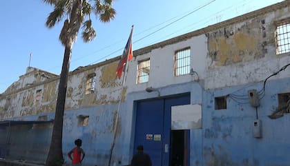 Personas miran el edificio de la prisión principal de Puerto Príncipe, Haití, el 3 de marzo de 2024, después de una fuga de varios miles de reclusos