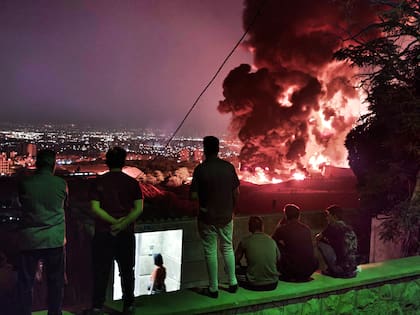 Personas observan el fuego y el humo de un ataque israelí contra el depósito de petróleo de Shahran el 15 de junio de 2025 en Teherán, Irán. El ministro de Asuntos Exteriores iraní afirmó que el país respondería de forma decisiva y proporcional a la oleada de ataques que Israel lanzó desde la madrugada del 13 de junio. Los ataques se dirigieron a múltiples instalaciones militares, científicas y residenciales, así como a altos funcionarios del gobierno