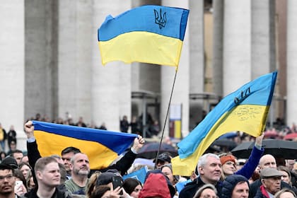 Personas ondean banderas ucranianas en la Plaza de San Pedro mientras el Papa Francisco se dirige a la multitud durante su oración del Ángelus dominical el 10 de marzo de 2024 en el Vaticano.