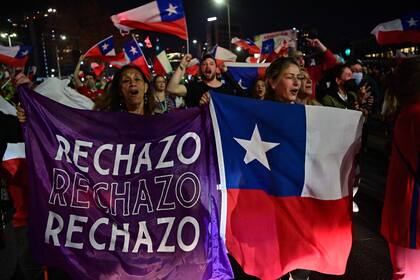 Personas que rechazan el proyecto de nueva constitución celebran tras conocer los resultados de la votación parcial del referéndum, en Santiago, el 4 de septiembre de 2022