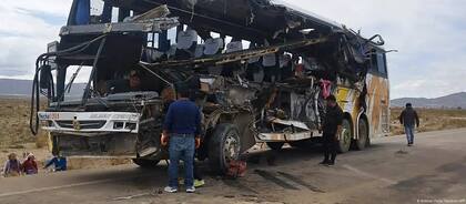 Personas revisan los restos de uno de los autobuses.
Imagen: Bolivian Police Handout/AFP