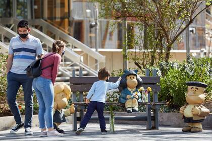 Personas se acercan a saludar a los personajes de Quino que se encuentran en la calle Arístides, de la Ciudad Capital, Mendoza
