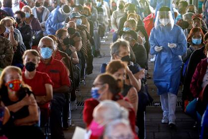 Personas sentadas tras recibir una dosis de la vacuna de Pfizer-BioNTech contra la  Covid-19 en el centro de vacunación instalado en el Instituto Cabanas en Guadalajara, estado de Jalisco, México, el 21 de marzo de 2021