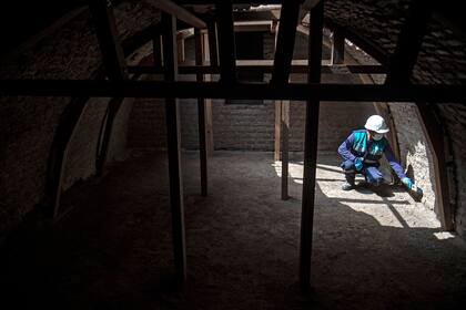 Un hombre trabaja en la cripta que fue encontrada en el antiguo hospital