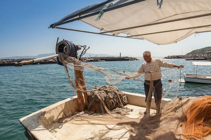 Pescador recogiendo sus redes en el puerto de Assos.