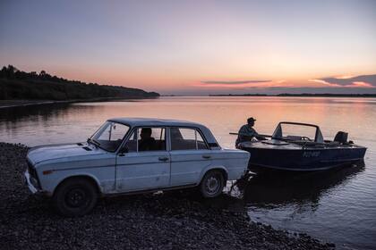 Pescadores arrastran su bote luego de la pesca en el río Amur
