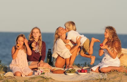 Picnic y amor sobre
la arena. Carola posa
con sus hijos mientras
toman la merienda.