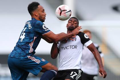 Pierre-Emerick Aubameyang del Arsenal, a la izquierda, e Ivan Cavaleiro del Fulham disputan la pelota en el 3-0 de los Gunners, que comenzaron sin el argentino Emiliano Martínez la nueva temporada de la Premier League.