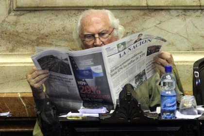 Pino Solanas lee LA NACION durante el debate en Diputados sobre el traspaso del subte al gobierno de la ciudad de Buenos Aires, en 2012