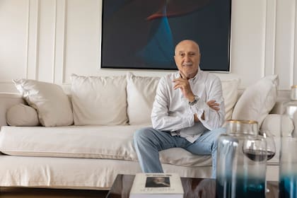 Pino sonríe en el living de su casa, detrás suyo un cuadro del artista argentino
Eduardo Mac Entyre, quien
fuera su primer profesor
de pintura