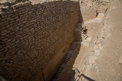 Un periodista baja las escaleras hacia el cementerio sur del rey Djoser, para filmarlo después de su restauración