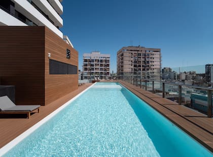 Piscina con solárium en el piso 13 con vistas panorámicas a la ciudad.