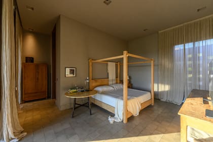 Piso calcáreo (Mosaicos Obregón), mesa con tapa de cuero (Renzo Galeano), cama de madera con dosel (Interiores B.AP) y cortinas de lino (Julia Sol)