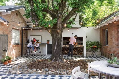 Piso de damero (Moltrasio). Banquetas (Manifesto). Cuadro (Helen Coelho). Guirnaldas (Pepe Iluminación).Sobre la mesa, maceta de cemento (Rama Diseño Verde).