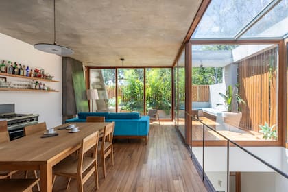 Piso de lapacho (Mazzei Maderas). Aberturas de incienso (Estudio Hanma). Sofá (Manifesto). Las lámparas con pantalla chata (Imdi) favorecen la continuidad visual entre espacios. Mesa de comedor y sillas (La Base Studio).