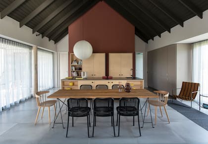 Piso de porcelanato (Bagno and Company), mesa de comedor hecha a medida, sillas de aluminio apilables de la firma italiana De Padova (todo de Monoccino). En las cabeceras, modelo ‘J104’ de Jørgen Bækmark (Hay).