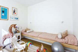 Piso de PVC símil madera (Barugel). Cama hecha a medida en madera de guatambú. La jirafa es herencia de la tía de Nerolí. La silla y la ropa de cama fueron traídas de un viaje (Ikea).