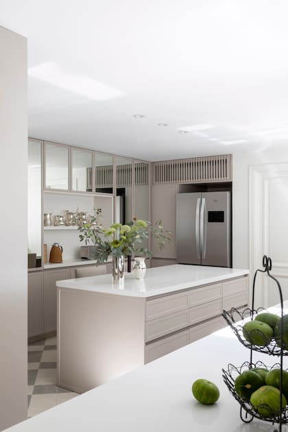 Piso granítico, amoblamiento gris cálido con alacenas espejadas para maximizar la luz de esta cocina interna