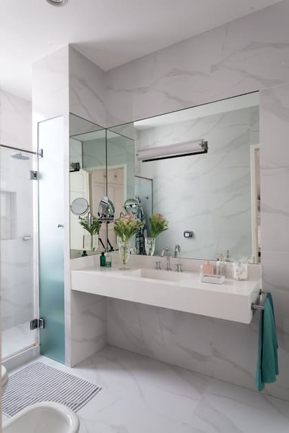 Piso y pared de porcelanato ‘Bianco Apuano’ (Vite). Mesada suspendida de Silestone con bacha integrada.