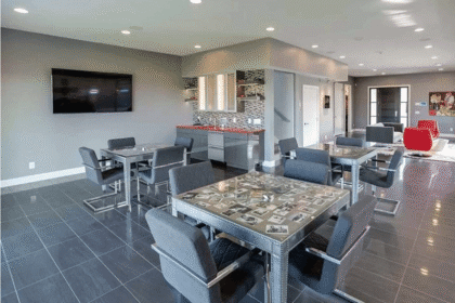 Pisos en colores oscuros, mobiliario en la gama del gris y algunos detalles en colores vivos son los detalles que comparten el living y la cocina