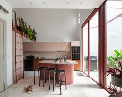 Pisos y alzadas en mosaico granítico (Esede Revestimientos) y mesadas de pórfido ‘Rosa Leather’ (Marmoles Granitos GyG). Isla de chapa a medida diseñada por el Estudio con banquetas de hierro (Casa Vissuta)