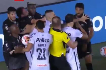 Pitana abraza a Aguirre en medio del tumulto. Más tarde, el futbolista se caerá y luego se irá expulsado