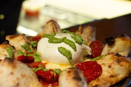 Pizza con burrata, pesto y tomates secos.