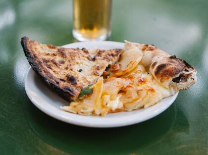 Pizza de papa confitada, ricota, muzarella, queso sbrinz, pimentón ahumado y hierbas