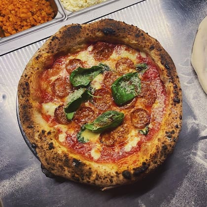 Pizza de pepperoni, tomate, mozzarella, albahaca y miel picante