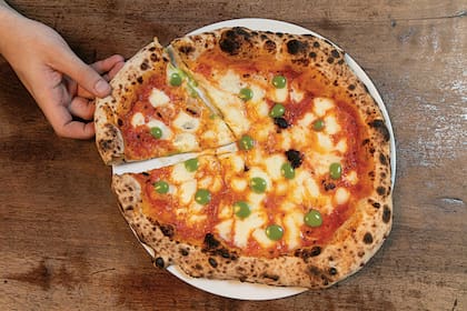 Pizza de salsa de tomate cherry asados, mozzarella y salsa holandesa de albahaca.