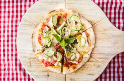 Pizzeta de calabaza, con queso brie, zucchini, tomates, flores de zapallo y paico.