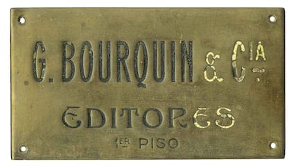 Placa de bronce del estudio del fotógrafo. El hecho de que esté corregida permite suponer que data de la época de su vinculación con Víctor Berthet y que fue reutilizada luego de la disolución de su sociedad con Kolhmann