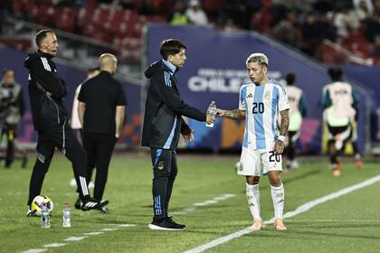 Placente habla con Gianluca Prestianni durante el 2-0 a México; el ex defensor puede ser el primero en consagrarse como jugador y como entrenador en un Mundial Sub 20.