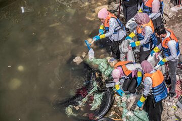 Voluntarios recogen plástico del río Nilo frente a la costa de la isla de Manial al-Roda en la capital de Egipto, El Cairo.