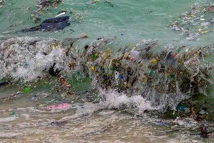 Una ola que transporta desechos plásticos y todo tipo de basura llega a una playa en Koh Samui, en el Golfo de Tailandia.