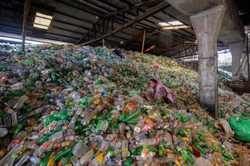 Un trabajador clasifica botellas de plástico usadas en una fábrica de reciclaje en Dhaka.