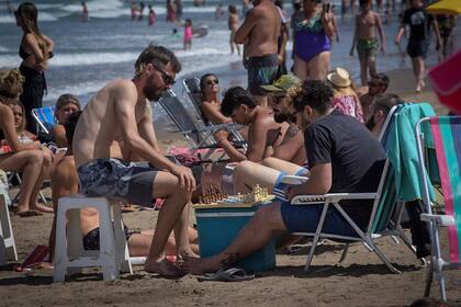 Tomar sol, pasar el día con amigos, la actividad en la playa tiene poca distancia social y pocos barbijos