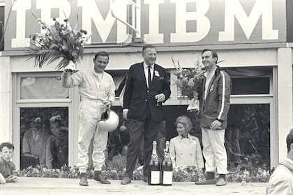 Podio. Bruce McLaren y Chris Amon flanquean al sonriente Henry Ford II, quien por fin tenía su "vendetta" sobre Ferrari
