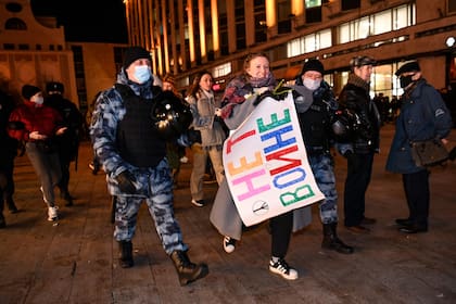 Agentes de policía detienen a una mujer durante una protesta contra la invasión rusa de Ucrania en Moscú el 24 de febrero de 2022 (Foto de Kirill KUDRYAVTSEV / AFP)
